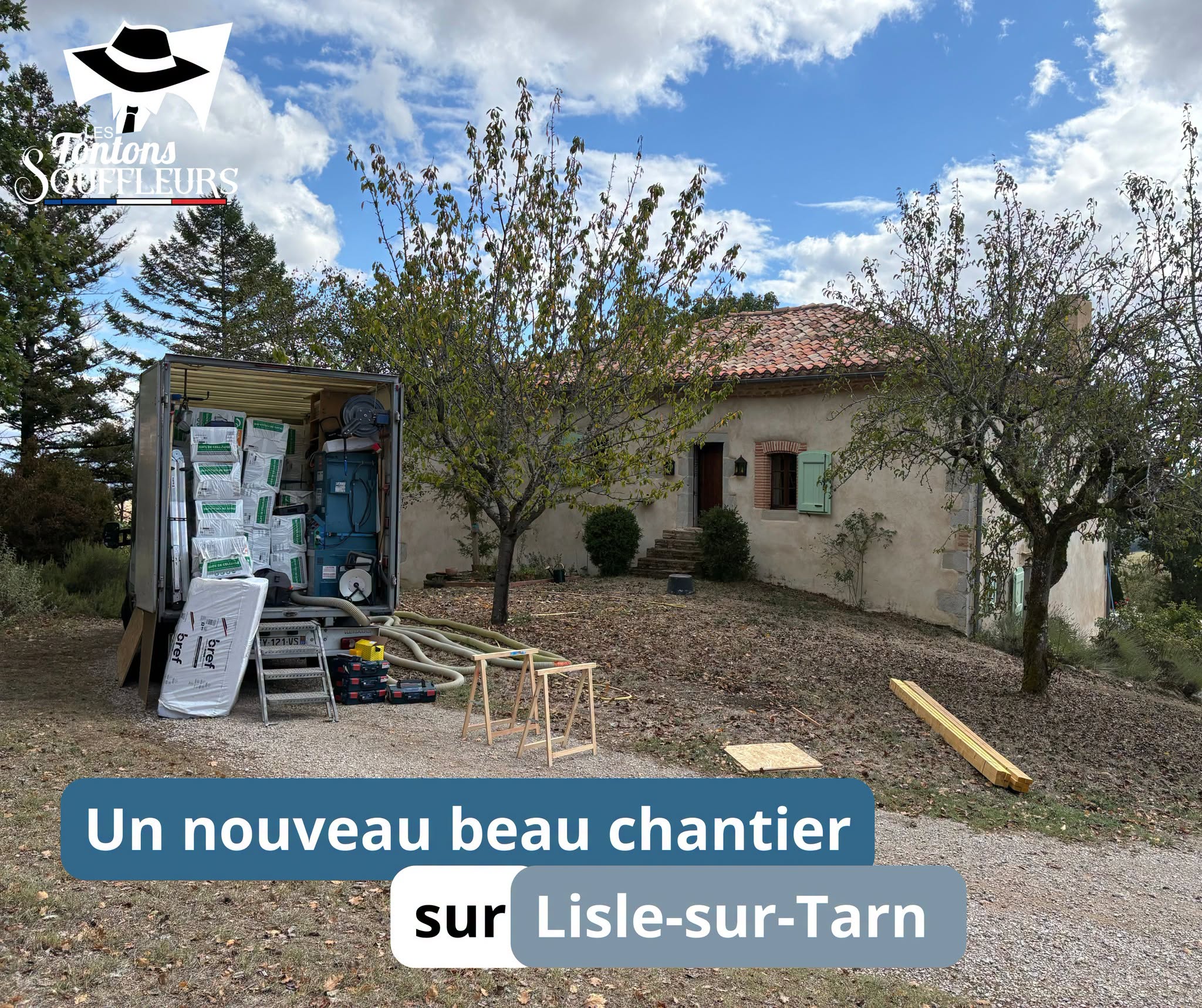 Camion des Tontons Souffleurs chargé de sacs de ouate de cellulose et de matériel de soufflage devant une maison ancienne à Lisle-sur-Tarn